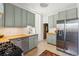 Modern kitchen featuring light green cabinets, butcher block countertops, and stainless steel appliances at 1519 E 29Th Ave, Denver, CO 80205