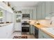 Stylish kitchen with sleek appliances, light green cabinets, wood countertop, and bright natural light at 1519 E 29Th Ave, Denver, CO 80205