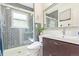 Modern bathroom featuring gray tiled shower with glass door, sleek vanity, and updated toilet at 3325 Irving St, Denver, CO 80211