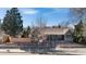 Charming exterior view of home with mature trees, a retaining wall, and a welcoming front porch at 3325 Irving St, Denver, CO 80211