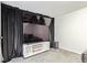 Cozy living room featuring entertainment center with triple-stacked television and dark curtains at 3325 Irving St, Denver, CO 80211