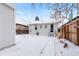 Backyard view with a partial view of a detached garage and a fenced yard covered in snow at 3438 N York St, Denver, CO 80205