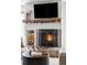 Close-up of a cozy fireplace with wooden mantle, stacked logs, and a decorative fireplace screen at 377 Pearl St # 5, Boulder, CO 80302