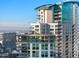 Modern condo building with curved glass, multiple balconies, and an upper deck on a clear day at 2001 Lincoln St # 2524, Denver, CO 80202