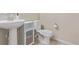 Cozy bathroom with a pedestal sink, white toilet, and cabinet at 1226 S Fulton St, Aurora, CO 80247