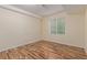 A simple bedroom featuring wood-look flooring, a window providing natural light and neutral paint at 1226 S Fulton St, Aurora, CO 80247