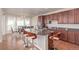 Modern kitchen featuring granite counters, stainless steel appliances, dark wood cabinetry, and seating at the island at 1226 S Fulton St, Aurora, CO 80247