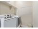Laundry room with modern washer and dryer units, along with overhead shelving for storage and ample space at 1226 S Fulton St, Aurora, CO 80247