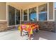 Covered patio with a vibrant outdoor dining area, slider doors and windows looking into the interior of the house at 1226 S Fulton St, Aurora, CO 80247