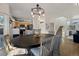 Bright dining area with a large round table and chairs, hardwood floors, and kitchen access at 16935 Buffalo Valley Path, Monument, CO 80132