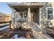 Front porch with stone pillars and a wooden bench, some snow on the ground at 16935 Buffalo Valley Path, Monument, CO 80132
