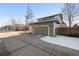 Two-car garage with a concrete driveway and snow on the ground at 16935 Buffalo Valley Path, Monument, CO 80132