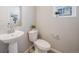 Powder room with pedestal sink, modern fixtures, and decorative mirror at 22033 E 38Th Pl, Aurora, CO 80019