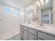 Bright main bathroom featuring dual sinks, a walk-in shower with subway tile, and modern lighting at 22033 E 38Th Pl, Aurora, CO 80019