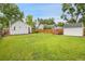 Expansive backyard with lush green grass, a wooden fence, mature trees, and a shed at 2212 Ingalls St, Edgewater, CO 80214