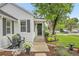 Charming home entrance featuring a beautiful garden, seating, and a black front door at 2212 Ingalls St, Edgewater, CO 80214
