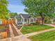 Landscaped front yard with a charming white home and tree at 2212 Ingalls St, Edgewater, CO 80214