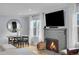Cozy living room with stone fireplace, dining table, and hardwood floors at 2212 Ingalls St, Edgewater, CO 80214