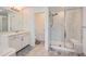 Bright bathroom featuring a walk-in shower with marble tile and a double sink vanity at 154 Cortona Pl, Castle Pines, CO 80108