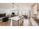 Open kitchen with center island, stainless steel appliances, and adjacent living and dining areas at 154 Cortona Pl, Castle Pines, CO 80108
