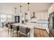 Bright kitchen with white cabinets, a large island, pendant lighting, and stainless steel appliances at 154 Cortona Pl, Castle Pines, CO 80108