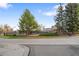 Street view of building with black metal fence and mature trees at 8112 Gray Ct # 394, Arvada, CO 80003