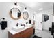 Modern bathroom featuring double sinks, wood cabinets, and elegant lighting fixtures at 5401 E Dakota Ave # 3, Denver, CO 80246