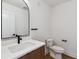 Powder room with modern fixtures, an arched mirror and wood vanity at 3430 W 25Th Ave, Denver, CO 80211