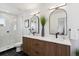 A modern bathroom with double sinks, wood cabinets, black tile floors, and a glass shower at 3430 W 25Th Ave, Denver, CO 80211