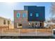 Modern two-story home exterior with brick and metal accents, a wooden fence and green grass at 3430 W 25Th Ave, Denver, CO 80211