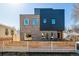 Modern two-story home featuring mixed brick and dark metal exterior, complemented by a stylish wood fence at 3430 W 25Th Ave, Denver, CO 80211