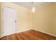 Bedroom with hardwood floors, a light fixture, and a door at 1450 Albion St # 204, Denver, CO 80220