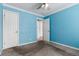 Bedroom with carpet, blue walls, a ceiling fan and two white doors, with another room beyond at 1450 Albion St # 204, Denver, CO 80220