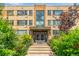 Inviting brick apartment building at 1450, with lush greenery framing the entrance at 1450 Albion St # 204, Denver, CO 80220