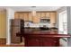 Kitchen with stainless steel refrigerator, wooden cabinets, and a dark wooden kitchen island at 1450 Albion St # 204, Denver, CO 80220