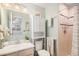 Light-filled bathroom featuring neutral-toned cabinets, tiles, and a shower with a curtain at 64 Nome Way # A, Aurora, CO 80012