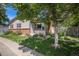 Charming single-Gathering home featuring a landscaped front yard and mature tree, creating a welcoming curb appeal at 64 Nome Way # A, Aurora, CO 80012