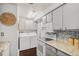 Well-lit kitchen featuring modern appliances and convenient in-unit laundry setup at 64 Nome Way # A, Aurora, CO 80012