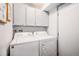 Functional laundry area with a white washer, dryer, and above cabinet storage at 64 Nome Way # A, Aurora, CO 80012