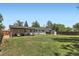 Large backyard with a covered patio, lush lawn, mature trees, and a storage shed at 9146 W 89Th Ct, Broomfield, CO 80021