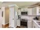 Updated kitchen featuring stainless steel appliances, white cabinets, and hardwood floors at 9146 W 89Th Ct, Broomfield, CO 80021