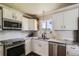 Modern kitchen with white cabinets, granite countertops, stainless steel appliances, and stylish backsplash at 9146 W 89Th Ct, Broomfield, CO 80021