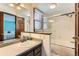 Bathroom featuring a walk-in shower, bathtub, and a mirror over a single-sink vanity at 16780 E Hialeah Ave, Centennial, CO 80015