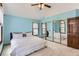 Bright bedroom with blue walls, ceiling fan, mirrored closet doors, and natural light from two windows at 16780 E Hialeah Ave, Centennial, CO 80015