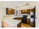 A well-lit kitchen with a skylight, oak cabinets, laminate countertops, and stainless-steel appliances at 16780 E Hialeah Ave, Centennial, CO 80015