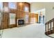 Spacious living room with a high ceiling, wood paneling, a brick fireplace, and large windows at 16780 E Hialeah Ave, Centennial, CO 80015