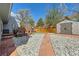 Backyard features gravel with a brick walkway, artificial grass and shed at 4071 E 126Th Pl, Thornton, CO 80241