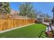 Fenced backyard with artificial grass and a storage shed, providing a private outdoor space at 4071 E 126Th Pl, Thornton, CO 80241