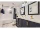 Elegant bathroom with double sinks, navy blue cabinets, and a subway tile shower at 4071 E 126Th Pl, Thornton, CO 80241