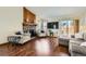 Cozy living room featuring a stone fireplace, hardwood floors, and comfortable seating arrangement at 4071 E 126Th Pl, Thornton, CO 80241